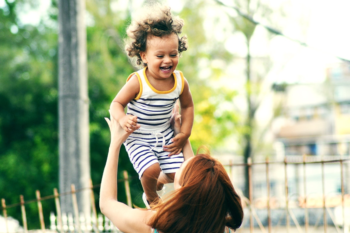 Mother raising a young child up in the air